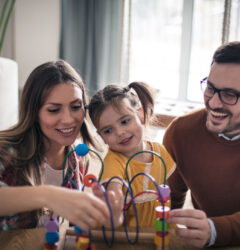 They put family time before anything else. Parents with daughter playing at home.