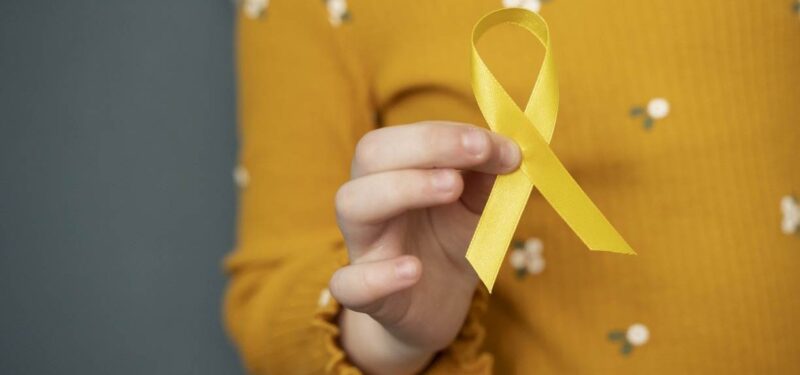 child_holding_yellow_ribbon-21723697